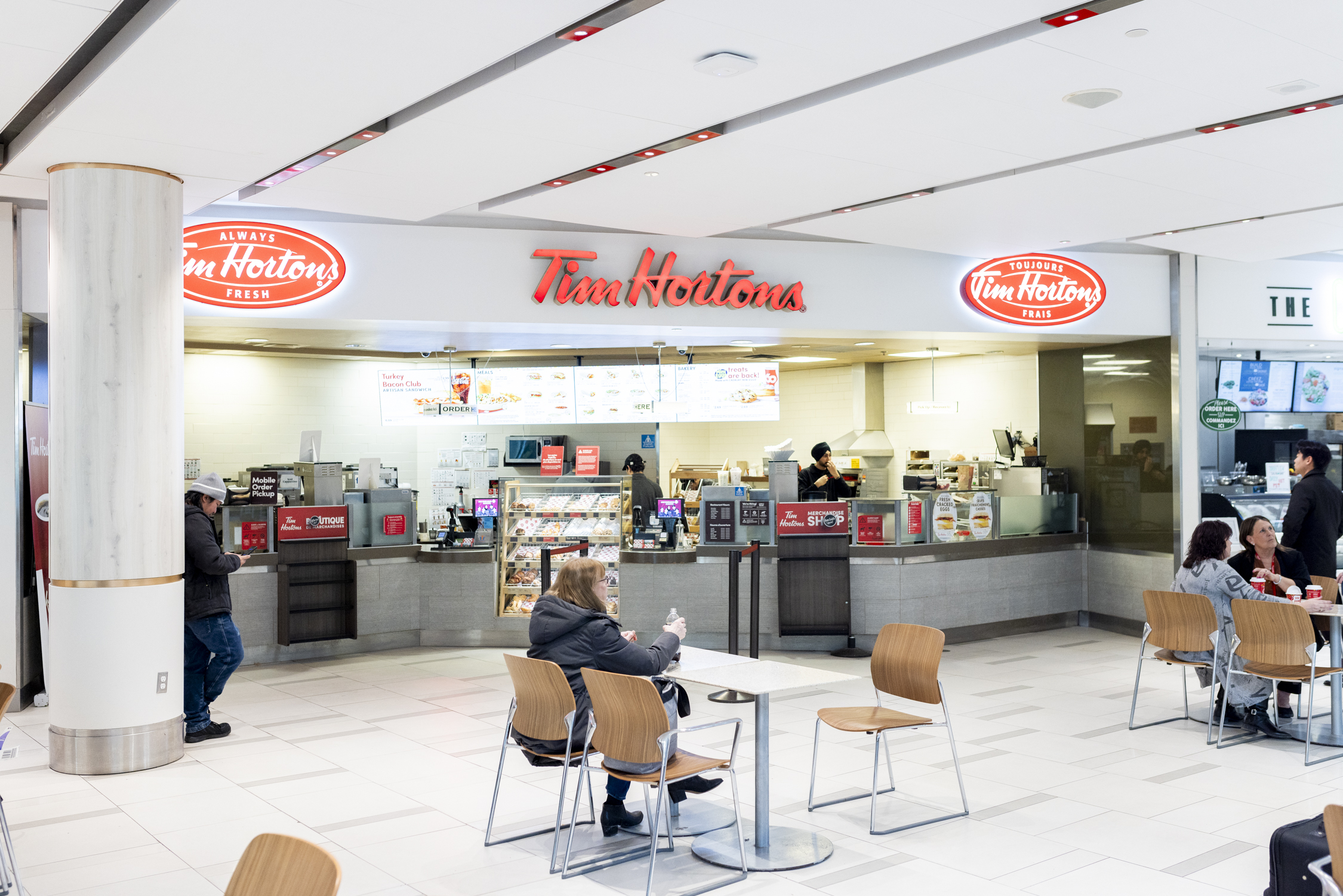 A person seated in front of a Tim Hortons